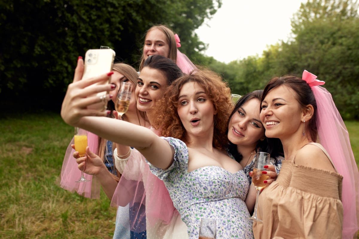 Kamarádky v růžových závojích si na rozlučce se svobodou dělají selfie